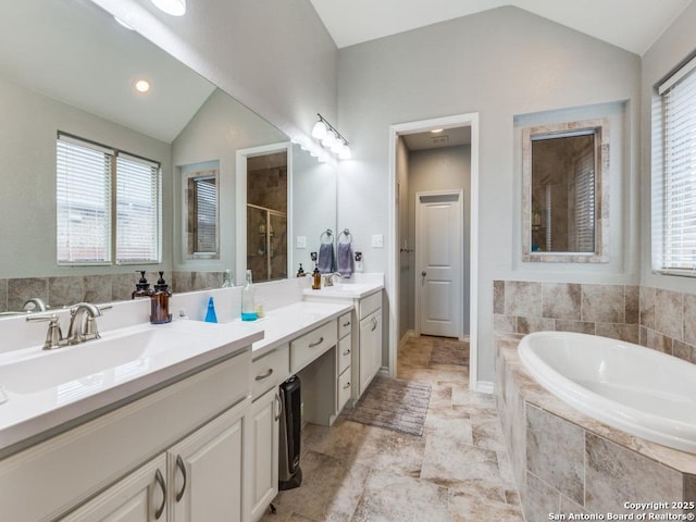 bathroom with lofted ceiling, independent shower and bath, and vanity