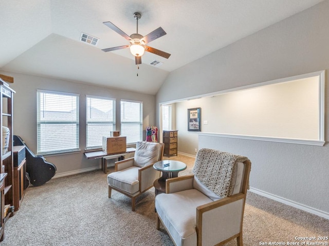 living area featuring ceiling fan, carpet floors, and vaulted ceiling