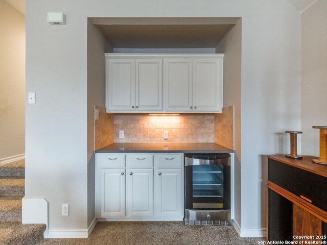 bar with wine cooler, backsplash, light carpet, and white cabinets