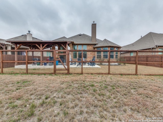 back of property with a yard and a patio area