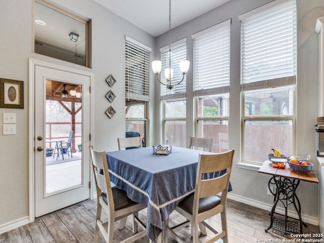 dining space with an inviting chandelier and light hardwood / wood-style flooring