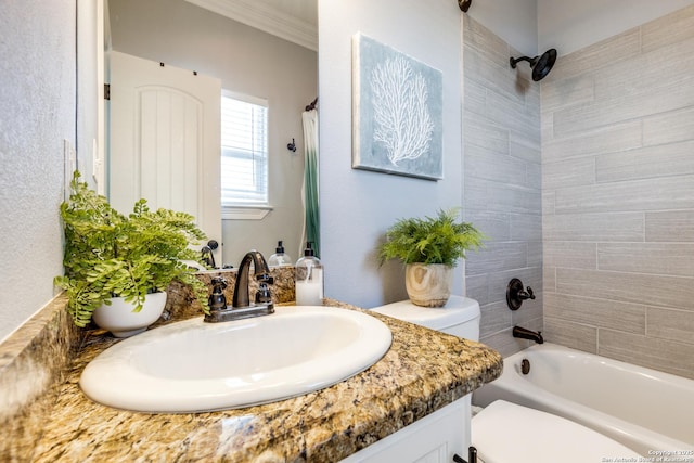 full bathroom with tiled shower / bath, vanity, toilet, and ornamental molding