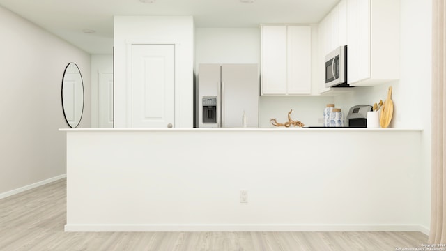 kitchen with light wood-type flooring, refrigerator with ice dispenser, and white cabinets