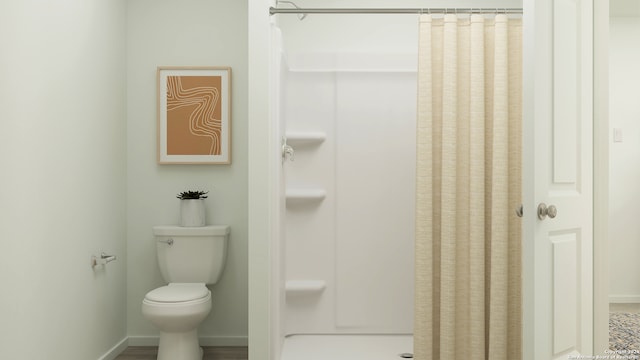 bathroom featuring walk in shower and toilet