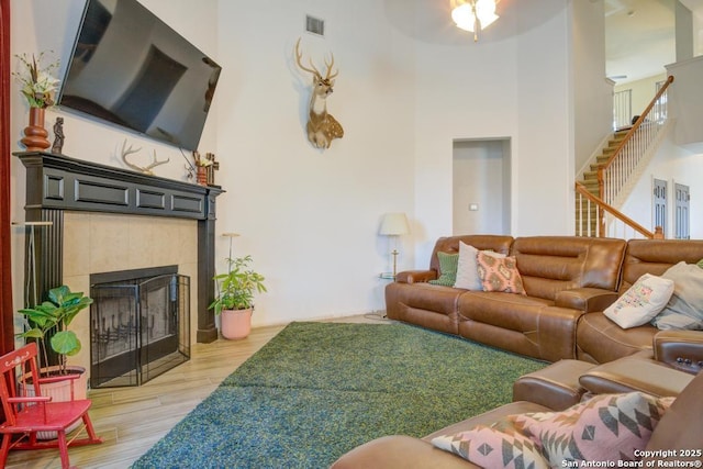 living room with a tile fireplace and light wood-type flooring