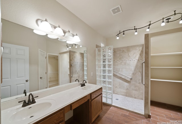 bathroom featuring vanity and tiled shower