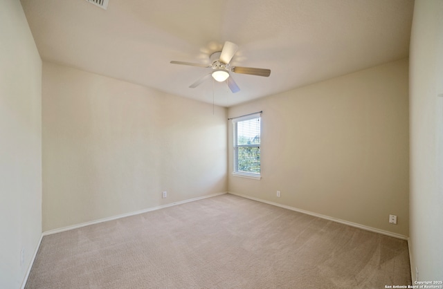 empty room featuring light colored carpet and ceiling fan