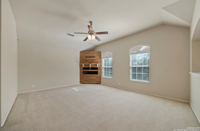 unfurnished living room with ceiling fan, light colored carpet, lofted ceiling, and a fireplace