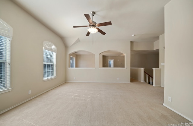 empty room featuring plenty of natural light, light colored carpet, and ceiling fan