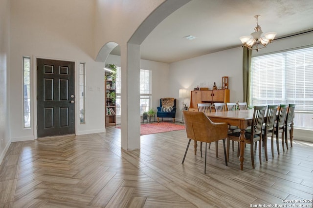 dining room featuring a notable chandelier, light parquet floors, and a wealth of natural light