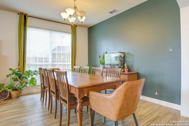 dining room with a notable chandelier and light wood-type flooring