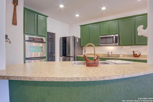 kitchen with sink, stainless steel appliances, and green cabinetry