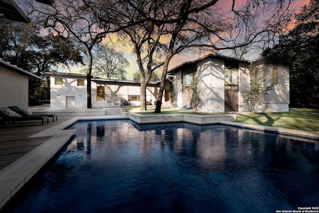 pool at dusk featuring a patio area