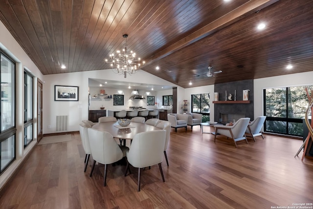 dining area featuring lofted ceiling, a healthy amount of sunlight, hardwood / wood-style floors, and a fireplace