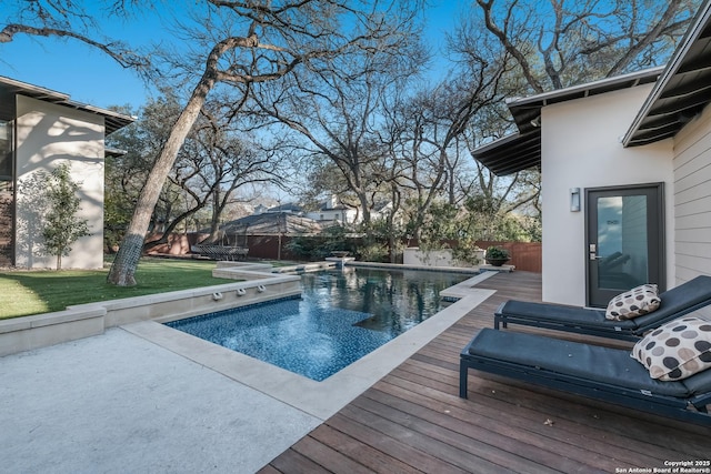 view of swimming pool featuring a wooden deck and a lawn