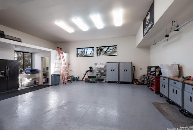 garage with black fridge with ice dispenser