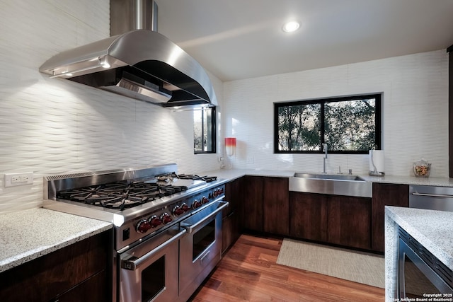 kitchen featuring backsplash, appliances with stainless steel finishes, sink, and island range hood