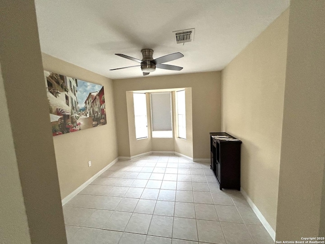 tiled spare room featuring ceiling fan