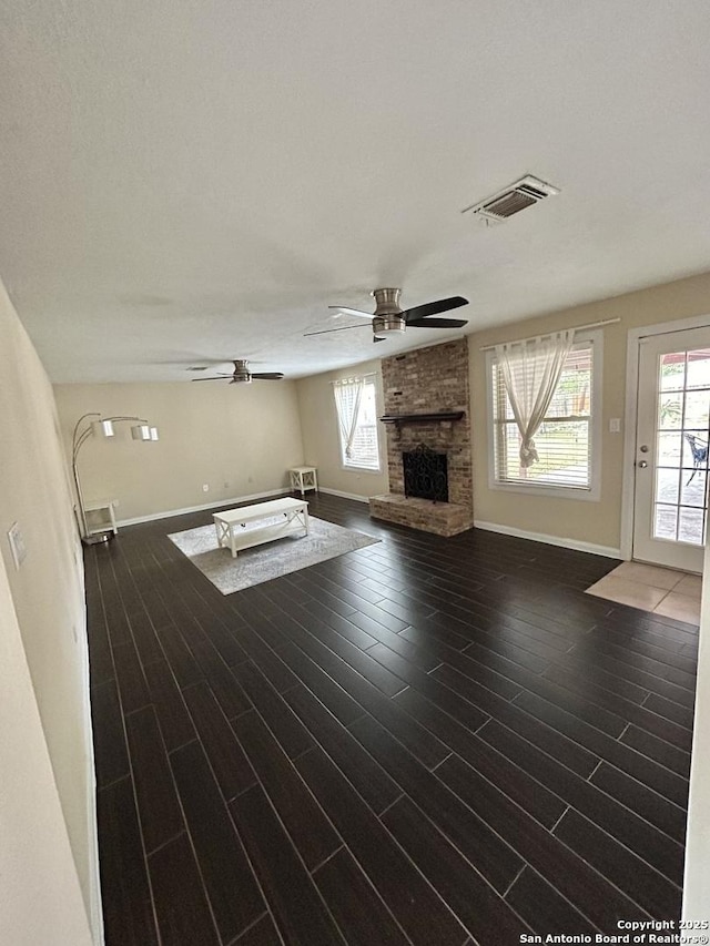 unfurnished living room featuring dark wood-type flooring, a fireplace, and ceiling fan