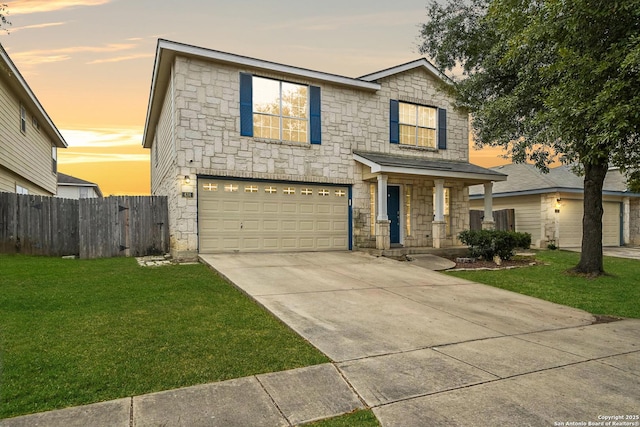 view of front of property with a garage and a lawn