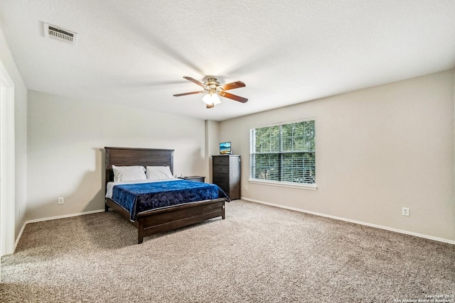 carpeted bedroom featuring ceiling fan and a textured ceiling