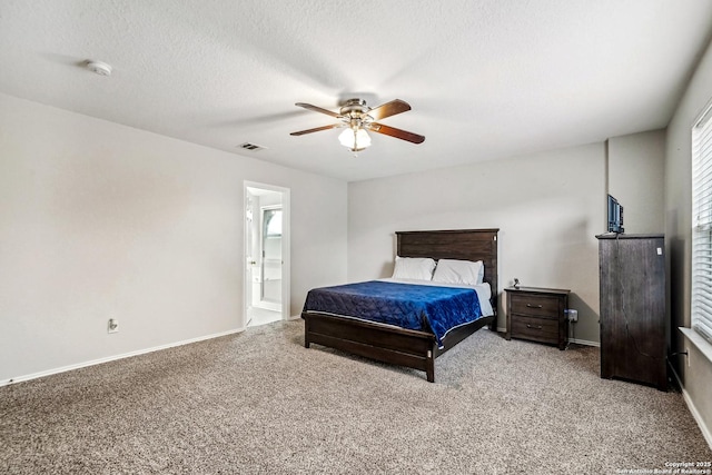 bedroom featuring ceiling fan, carpet flooring, ensuite bath, and a textured ceiling