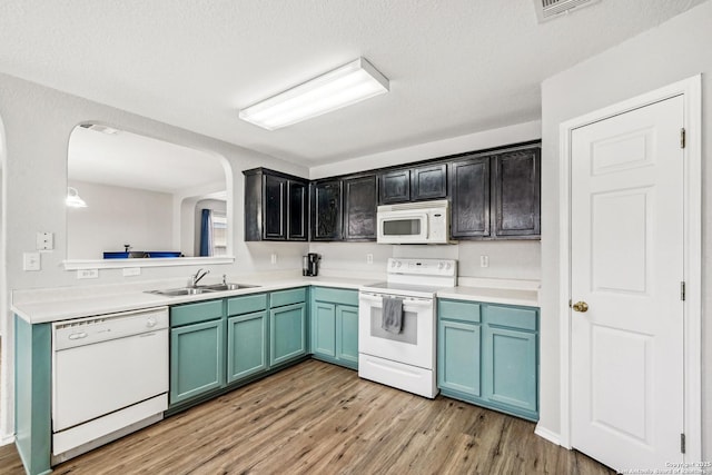 kitchen featuring white appliances, sink, and light hardwood / wood-style flooring