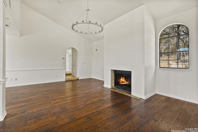 unfurnished living room with dark hardwood / wood-style flooring, high vaulted ceiling, and a chandelier