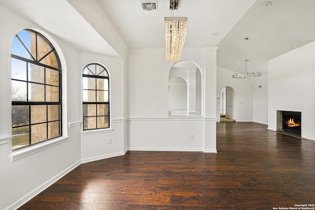 unfurnished dining area with crown molding, dark hardwood / wood-style flooring, and a notable chandelier