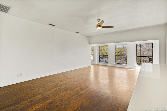 unfurnished living room featuring ceiling fan, hardwood / wood-style floors, and a textured ceiling