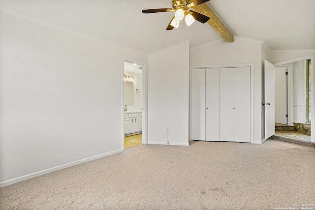 unfurnished bedroom featuring connected bathroom, crown molding, lofted ceiling with beams, light carpet, and a closet