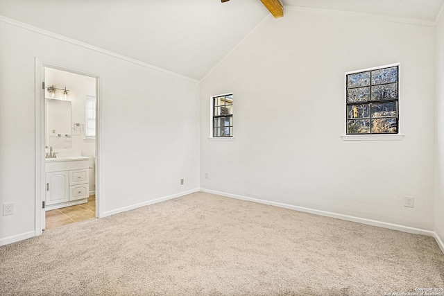 carpeted empty room featuring ceiling fan, a healthy amount of sunlight, ornamental molding, and vaulted ceiling with beams