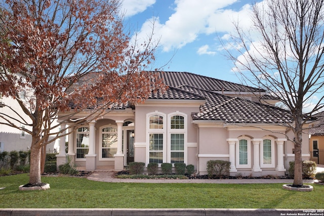 mediterranean / spanish-style home with a front yard