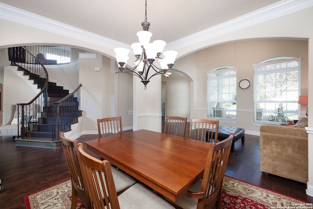 dining space featuring an inviting chandelier, ornamental molding, and dark hardwood / wood-style floors