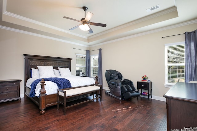 bedroom featuring ceiling fan, ornamental molding, a tray ceiling, and dark hardwood / wood-style flooring