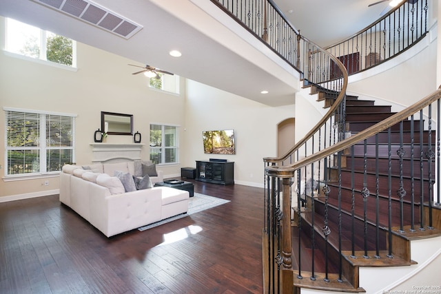 living room with ceiling fan, plenty of natural light, and dark hardwood / wood-style flooring