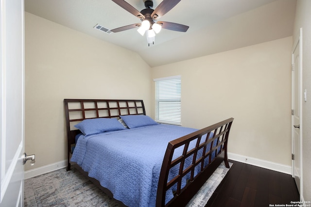 bedroom with dark hardwood / wood-style flooring, vaulted ceiling, and ceiling fan