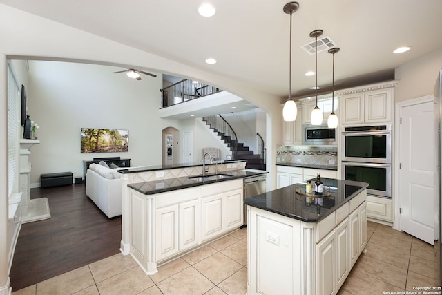 kitchen with pendant lighting, sink, stainless steel appliances, and a center island