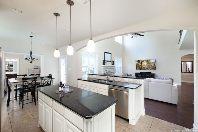 kitchen featuring white cabinetry, a center island, stainless steel dishwasher, and decorative light fixtures