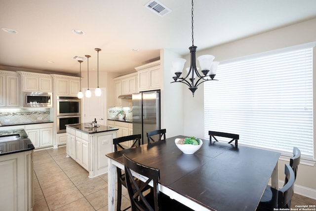 dining space with light tile patterned floors, a notable chandelier, and sink