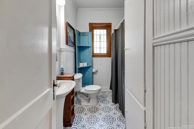 bathroom featuring tile patterned floors, ornamental molding, and toilet