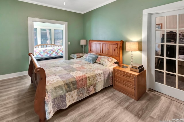 bedroom with ornamental molding and hardwood / wood-style floors