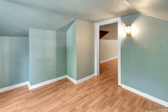 bonus room featuring vaulted ceiling and light hardwood / wood-style flooring