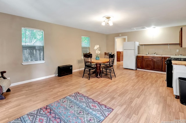 dining room featuring plenty of natural light, sink, and light wood-type flooring