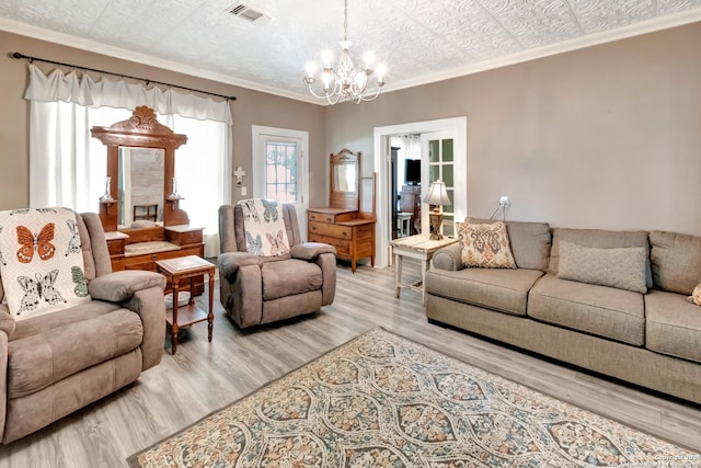 living room featuring hardwood / wood-style flooring, crown molding, and a chandelier