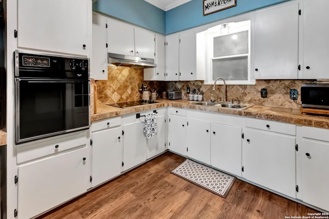 kitchen featuring sink, white cabinetry, black electric stovetop, wall oven, and hardwood / wood-style floors