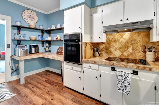 kitchen featuring white cabinetry, backsplash, black appliances, crown molding, and light hardwood / wood-style flooring