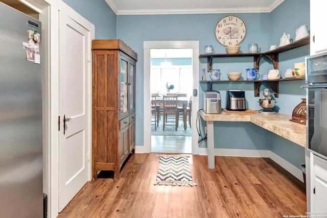 interior space featuring ornamental molding and light hardwood / wood-style flooring