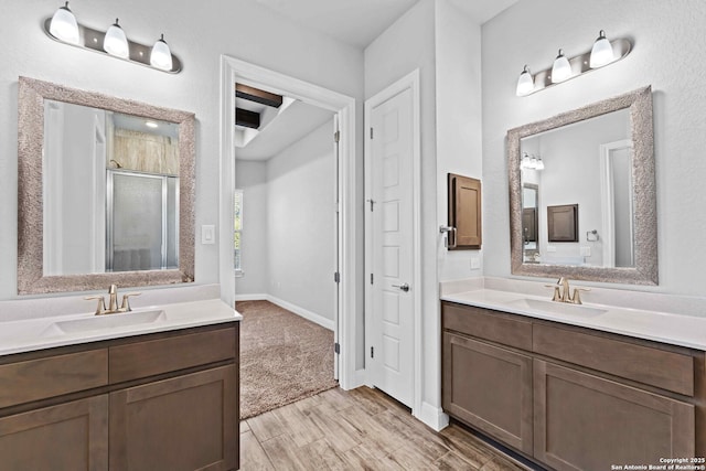 bathroom with vanity, hardwood / wood-style flooring, and a shower with door