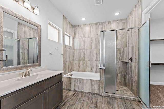 bathroom featuring plus walk in shower, hardwood / wood-style floors, and vanity